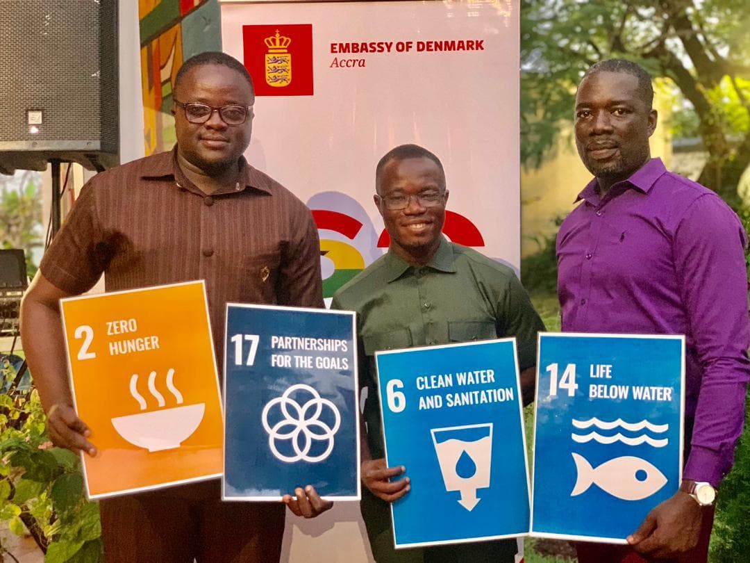 Des délégués de l'AYWF tenant des pancartes des Objectifs de développement durable, dont l'ODD 6 sur l'eau potable et l'assainissement, lors d'un événement à l'ambassade du Danemark à Accra