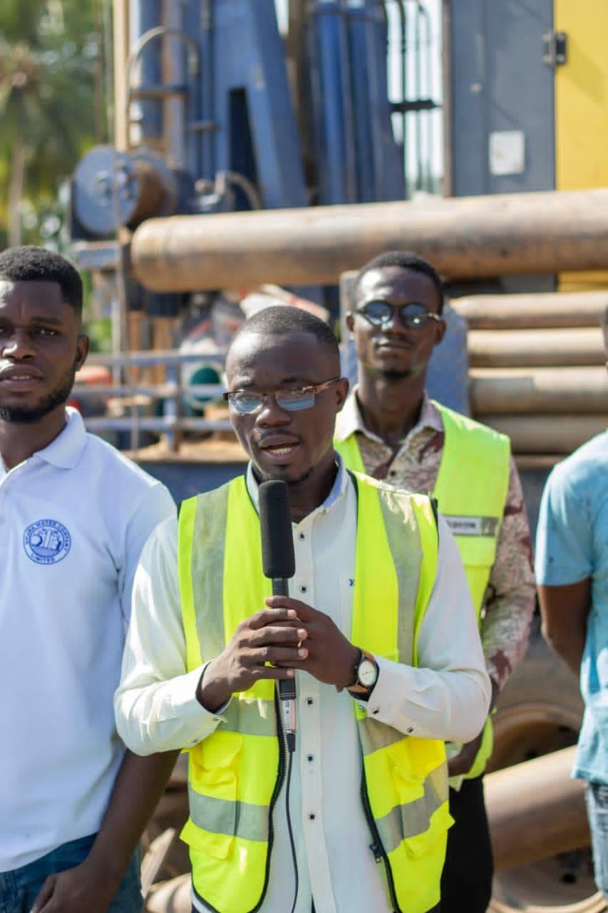 De jeunes membres de l'AYWF en gilets de haute visibilité sur un site hydraulique, l'un d'eux s'exprimant au micro